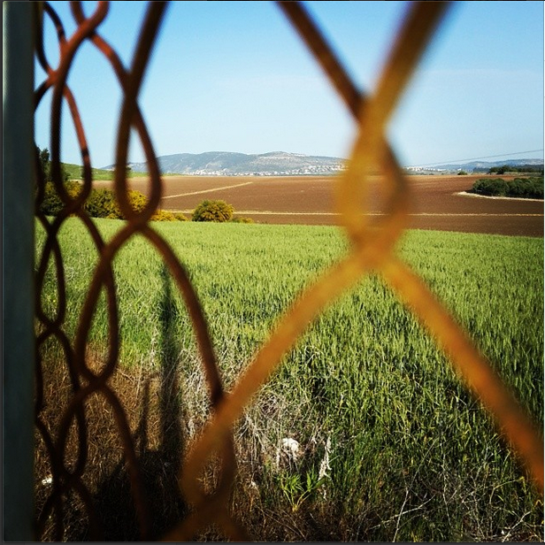 Tel Hannaton through fence, by Jen Maidenberg